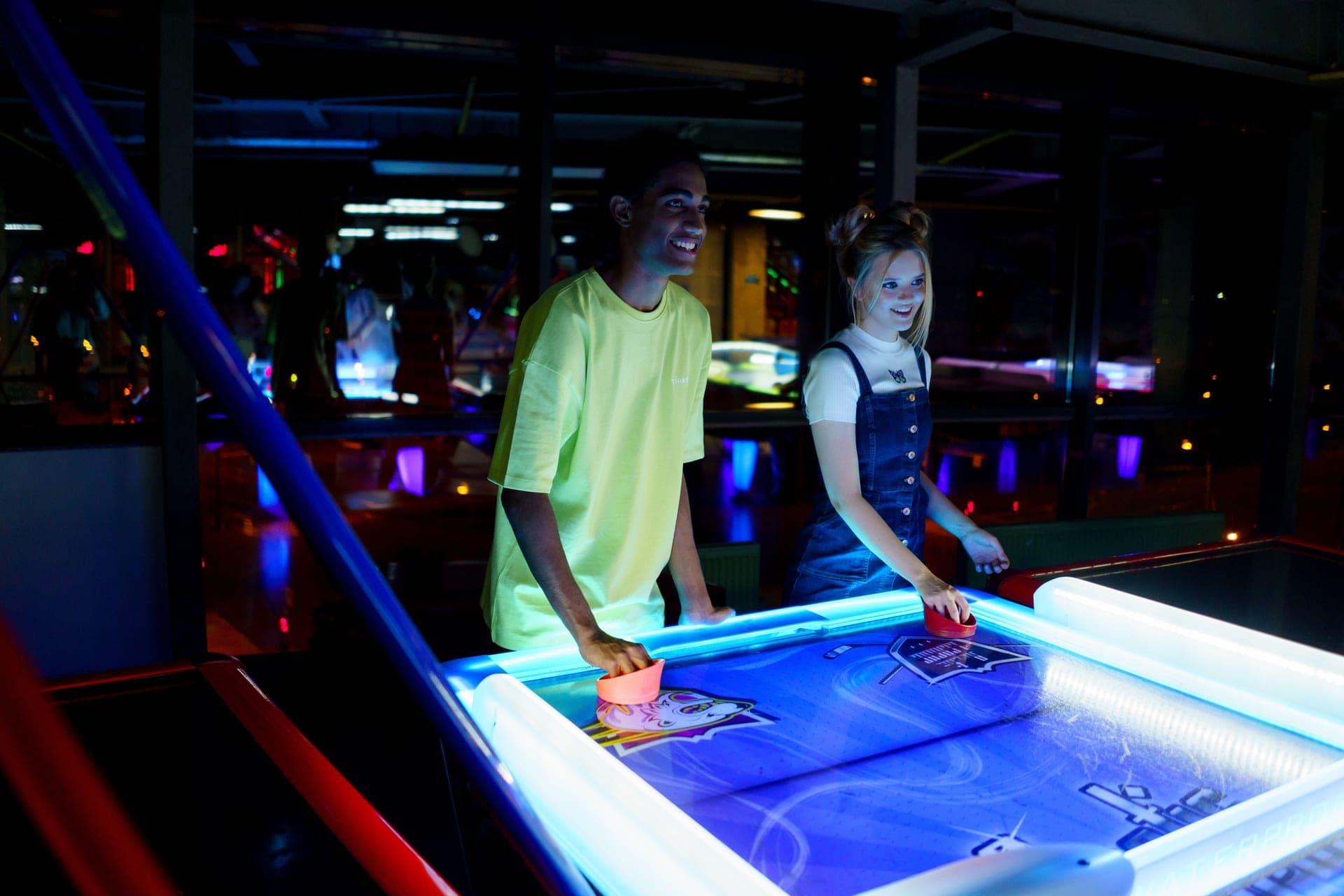 Two people playing air hockey on a home table