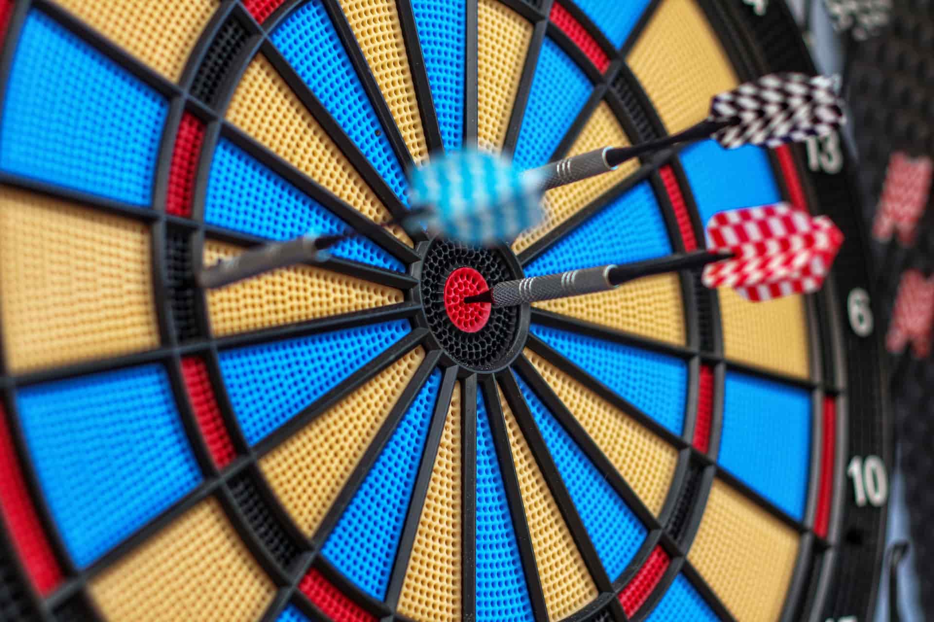 Darts hitting the bullseye on a dartboard