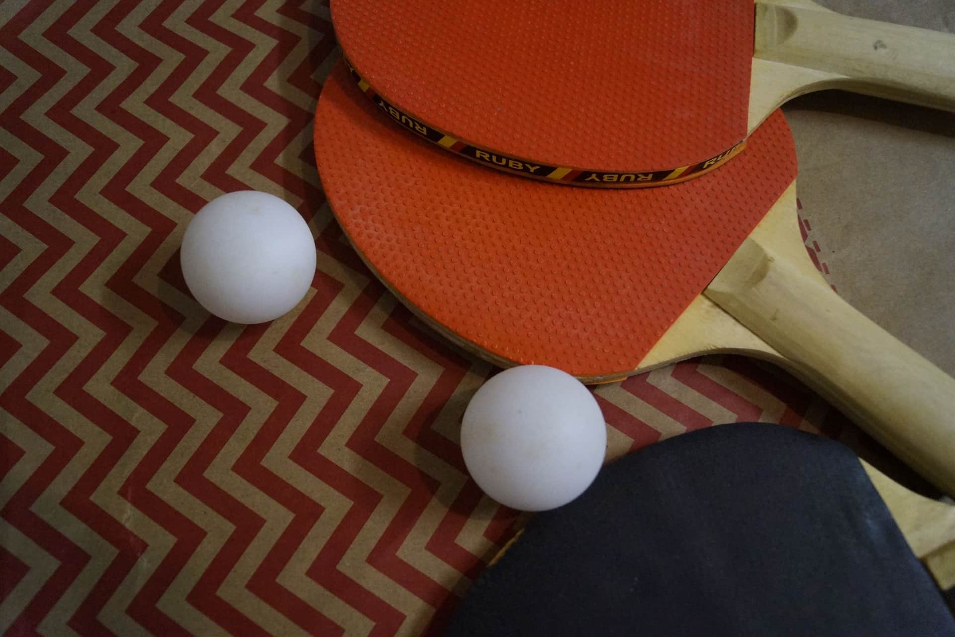 Table tennis paddles and balls laid out on a surface