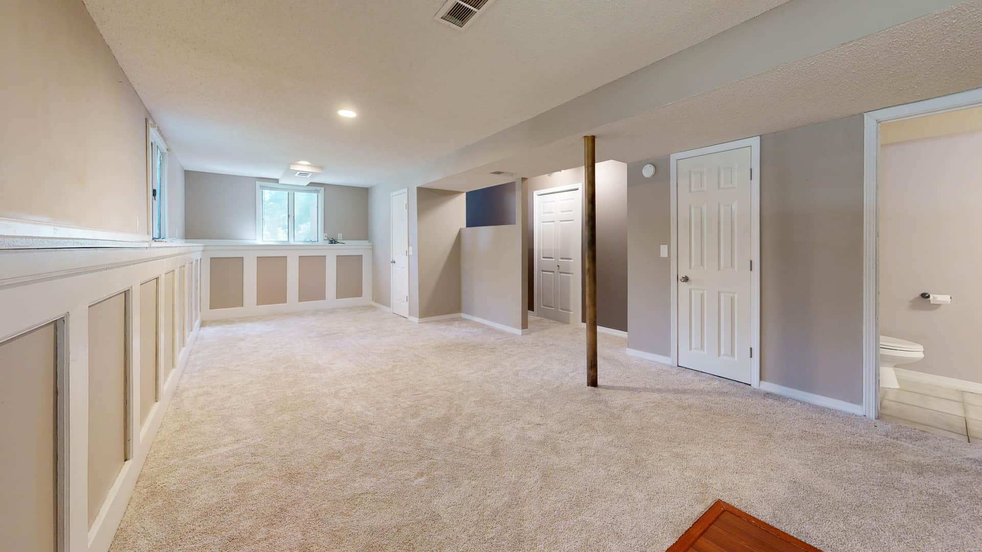 A bright, clean basement room with space for a table